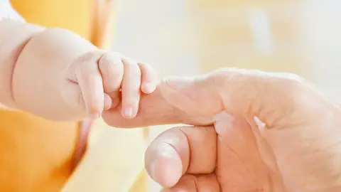 Manos de una persona mayor y de un bebé Manos de una persona mayor y de un bebé