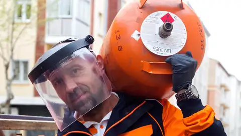 Un trabajador lleva a los hombros una bombona de butano Un trabajador lleva a los hombros una bombona de butano