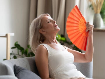Una mujer pasando calor se abanica