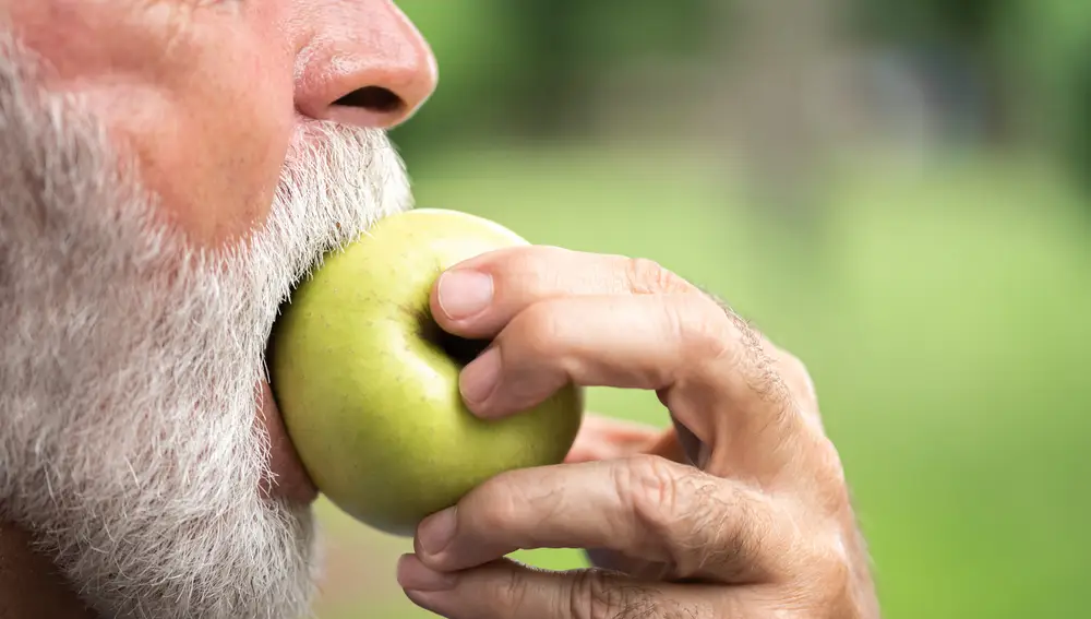 Hombre mayor comiendo una manzana