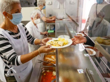 Una voluntaria y enfermera jubilada sirve comida de alta calidad, a personas mayores en un centro de Santiago