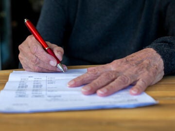 Mujer mayor firmando documentos