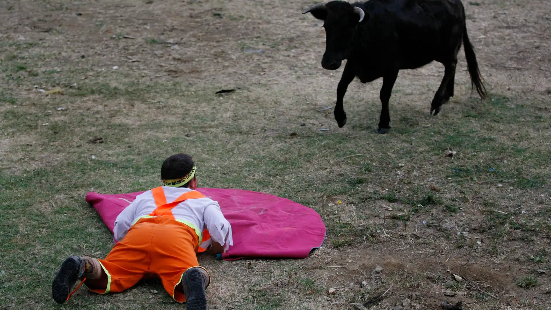 Un enano torero espera una vaquilla en una tarde taurina