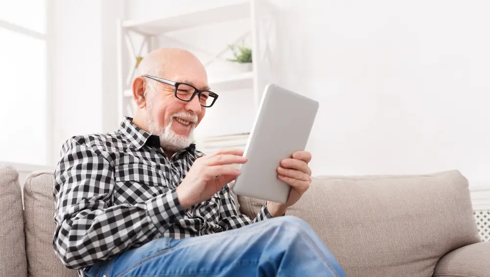 Hombre mayor navegando por Internet con una tablet