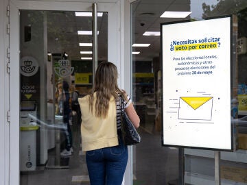 Imagen de una mujer entrando a la oficina de Correos