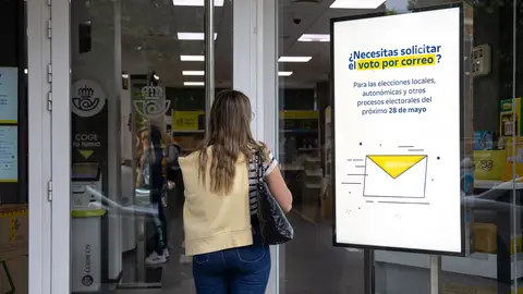 Imagen de una mujer entrando a la oficina de Correos Imagen de una mujer entrando a la oficina de Correos