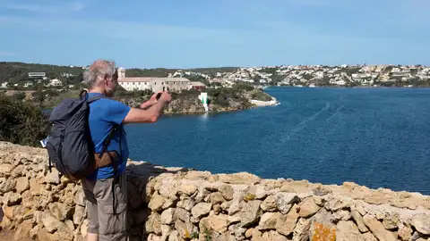 Un turista tomando una foto en una cala Un turista tomando una foto en una cala