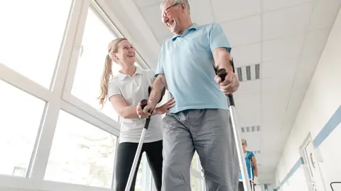 Hombre mayor usando unas muletas Hombre mayor usando unas muletas