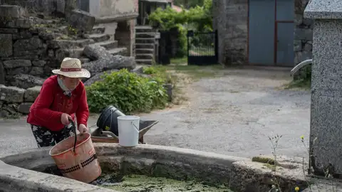 Mujer llenando cubos de agua Mujer llenando cubos de agua