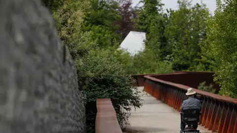 Hombre paseando con una silla de ruedas Hombre paseando con una silla de ruedas
