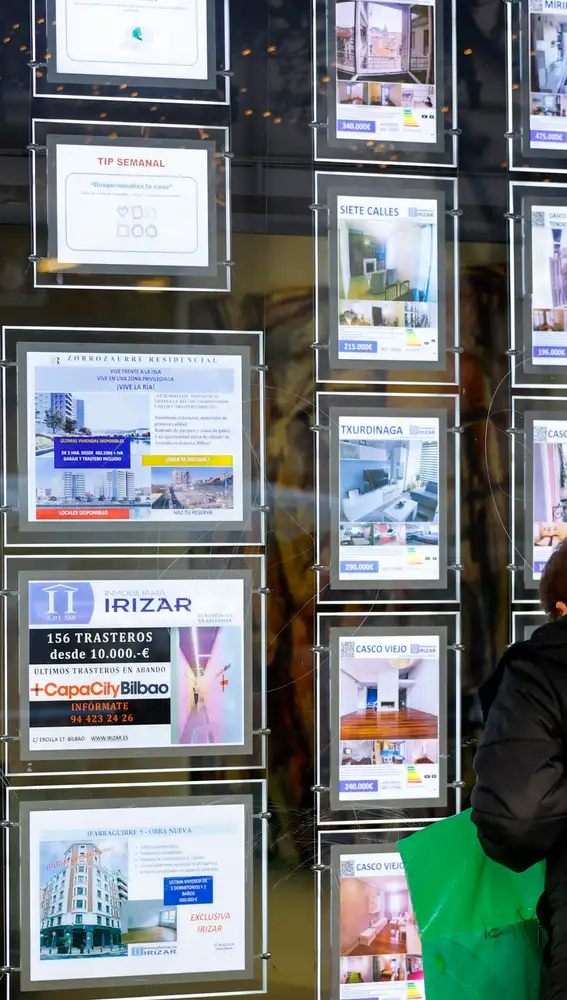Una mujer observa en una inmobiliaria Una mujer observa en una inmobiliaria