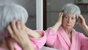 Mujer mayor mirándose al espejo