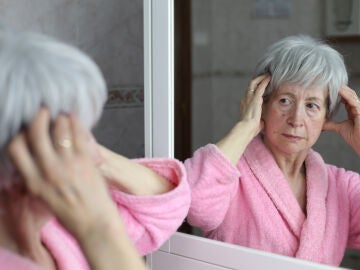 Mujer mayor mirándose al espejo