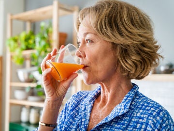 Mujer mayor tomando un zumo de fruta