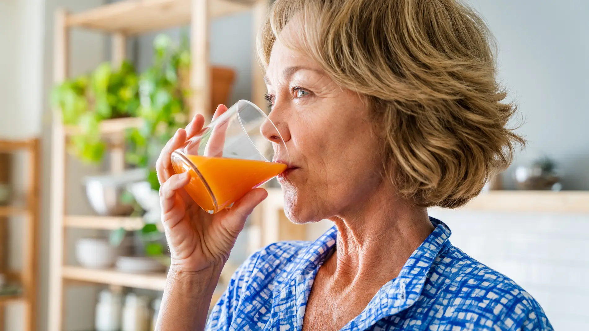 Mujer mayor tomando un zumo de fruta