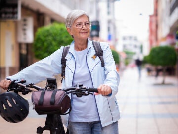 Mujer mayor en bicicleta por la ciudad