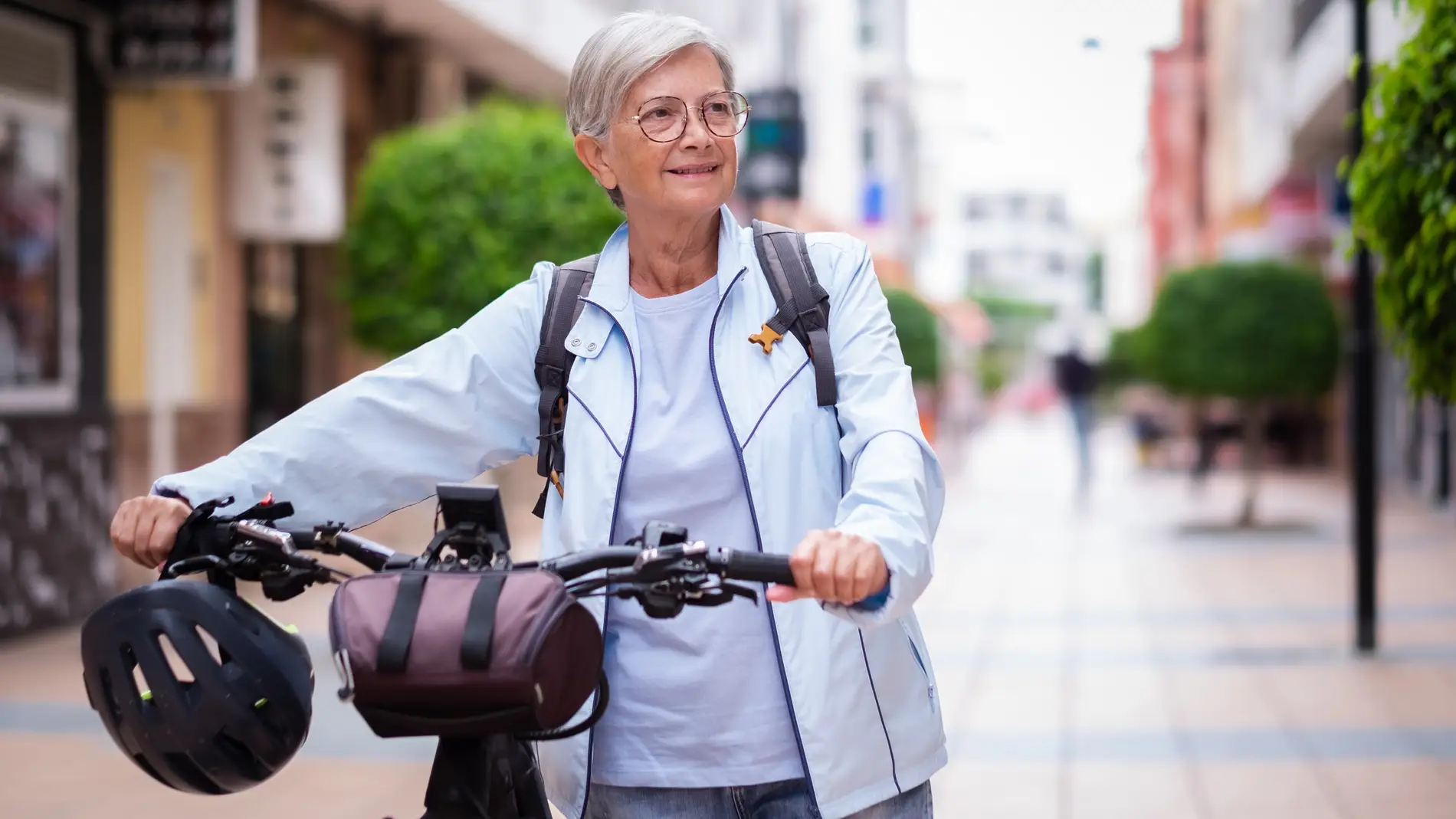 Mujer mayor en bicicleta por la ciudad