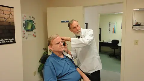 Médico revisando la audición del paciente Médico revisando la audición del paciente