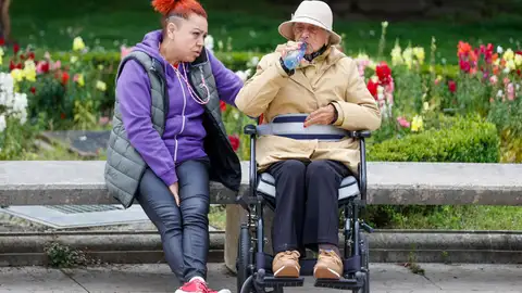 Una mujer mayor y dependiente con su cuidadora Una mujer mayor y dependiente con su cuidadora