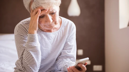 Mujer mayor mirando un teléfono móvil Mujer mayor mirando un teléfono móvil