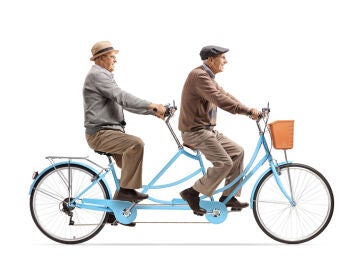 Dos hombres mayores montando en una bicicleta tándem