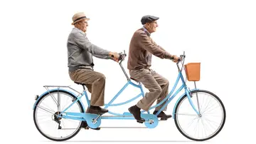 Dos hombres mayores montando en una bicicleta tándem