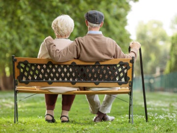 Una pareja mayor sentada en el banco de un parque
