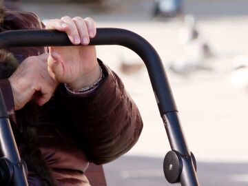 Manos de mujer mayor sujetando un andador