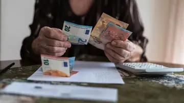 Mujer mayor contando el dinero de la pensión