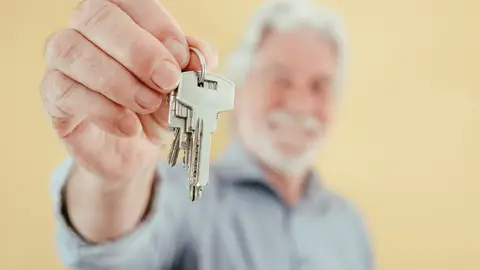 Persona mayor entrega las llaves de su casa Persona mayor entrega las llaves de su casa