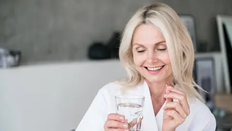 Mujer tomando tratamiento para la menopausia Mujer tomando tratamiento para la menopausia