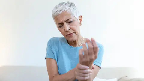 Una mujer con dolor en las articulaciones Una mujer con dolor en las articulaciones