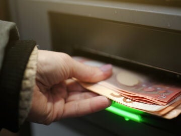 Mano sacando dinero del cajero
