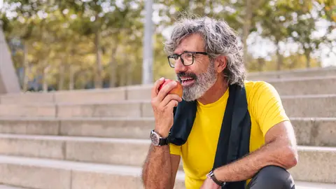 Hombre mayor comiéndose una manzana Hombre mayor comiéndose una manzana