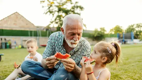 Abuelo y nietos comiendo sandía Abuelo y nietos comiendo sandía