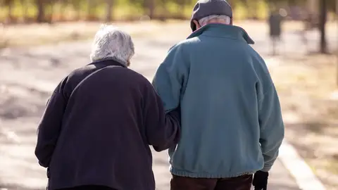 Una pareja de personas mayores paseando por el parque Una pareja de personas mayores paseando por el parque