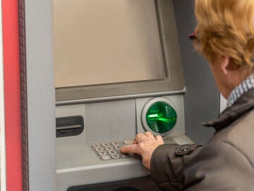 Mujer mayor sacando dinero del cajero