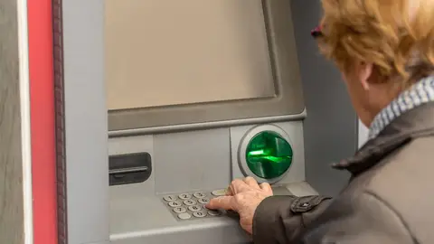 Mujer mayor sacando dinero del cajero Mujer mayor sacando dinero del cajero