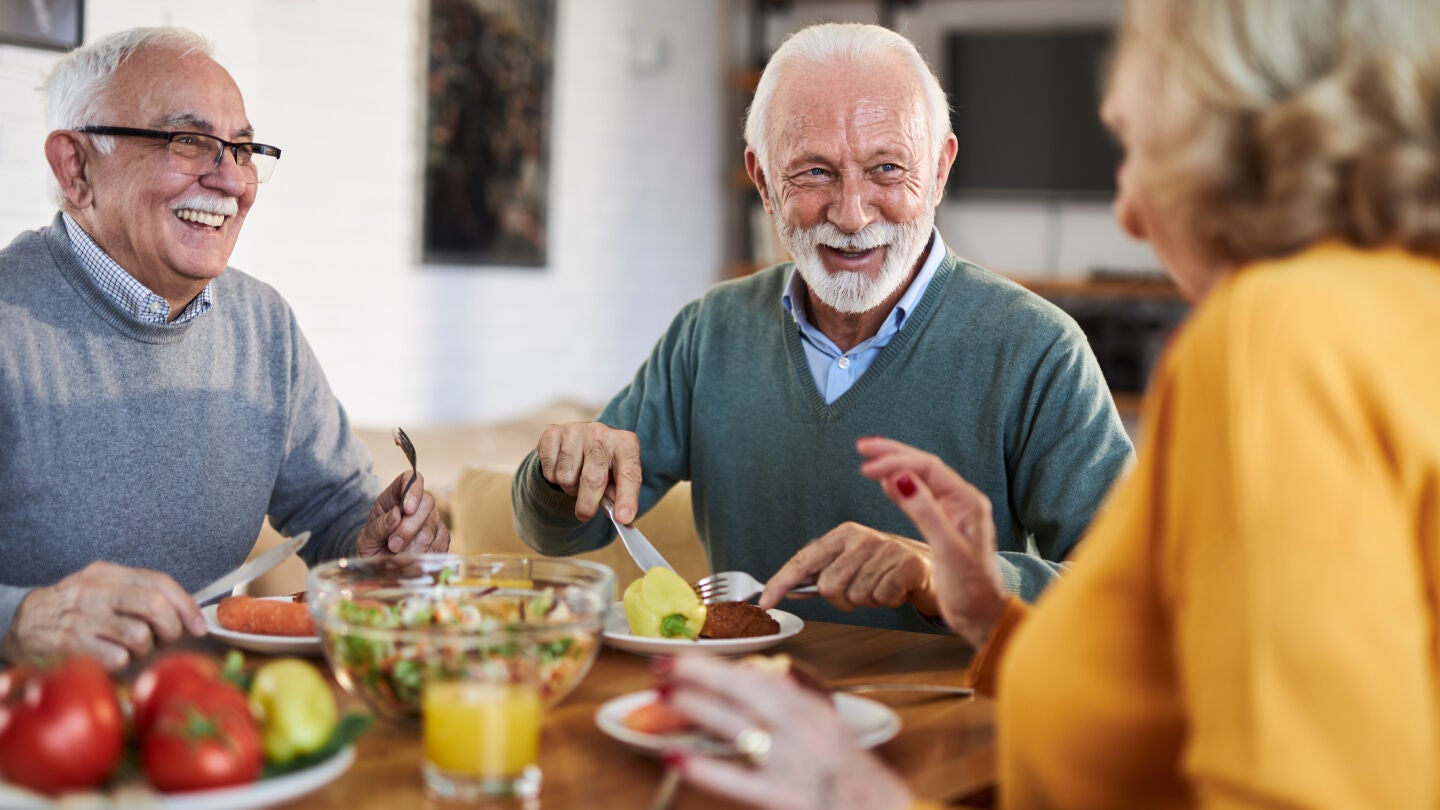 Personas mayores comiendo juntas 