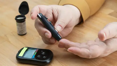 Paciente midiéndose la glucosa en sangre Paciente midiéndose la glucosa en sangre
