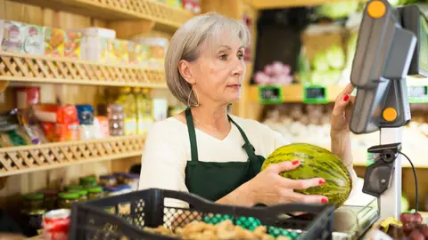 Mujer mayor atendiendo en una frutería Mujer mayor atendiendo en una frutería