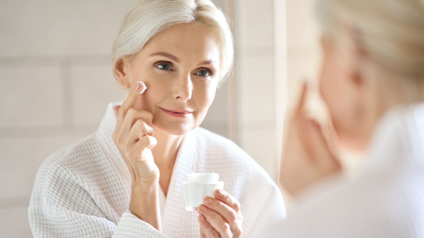 Mujer en sus 50 aplic&aacute;ndose una crema