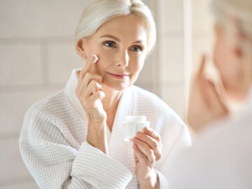 Mujer en sus 50 aplic&aacute;ndose una crema