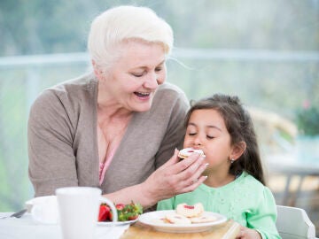 Abuela dando de comer a su nieta