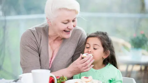 Abuela dando de comer a su nieta Abuela dando de comer a su nieta