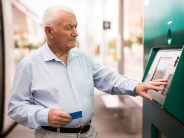 Hombre mayor sacando dinero en el cajero