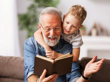 Un abuelo con su nieto leyendo un libro