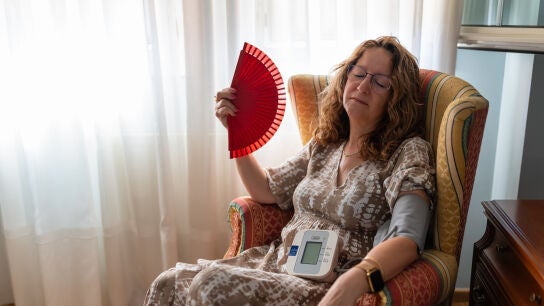 Mujer acalorada tom&aacute;ndose la tensi&oacute;n