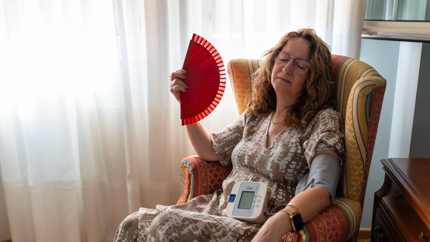 Mujer acalorada tom&aacute;ndose la tensi&oacute;n