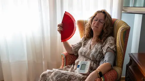 Mujer acalorada tomándose la tensión Mujer acalorada tomándose la tensión